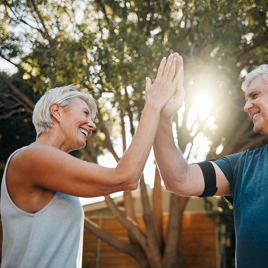 Fitness senior couple high five for support, teamwork and exercise motivation with sunshine, outdoor exercise and wellness. Success, achievement or target goal of elderly people for workout results.